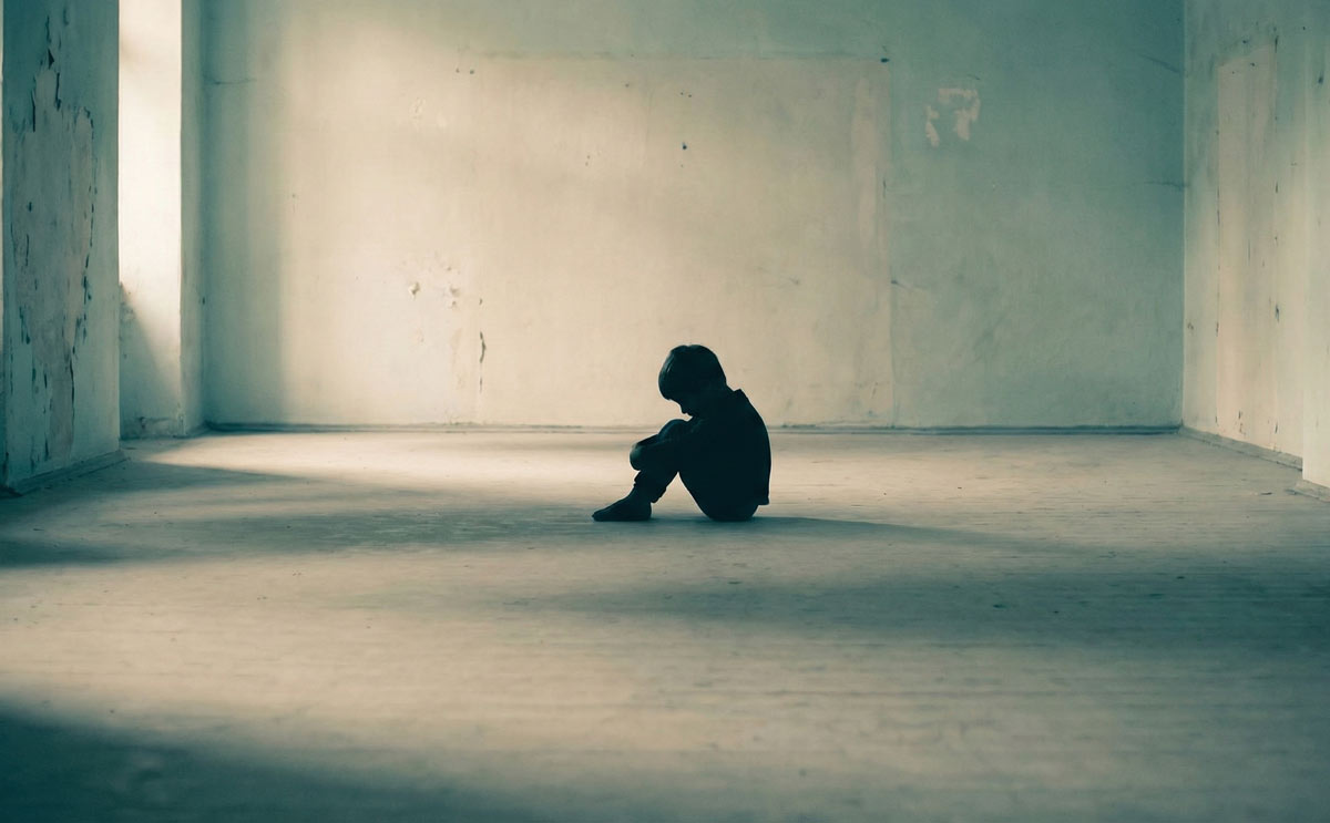 Lonely child sitting alone representing early childhood trauma as a root cause of Narcissistic Personality Disorder (NPD)